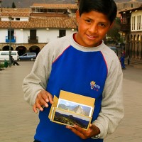Cusco boy displays Macchu Picho postcards